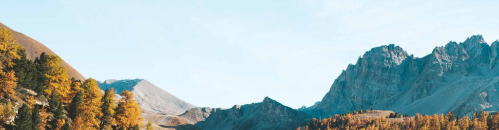 peaceful mountain landscape with autumn trees and blue sky