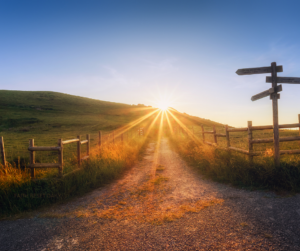 sunrise over country road with signpost symbolizing signs God is leading you in a new direction